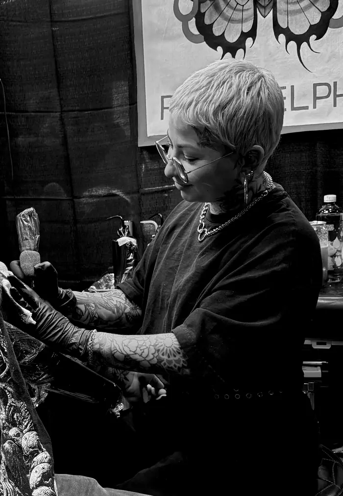 Lauren Lillian tattooing at a convention booth